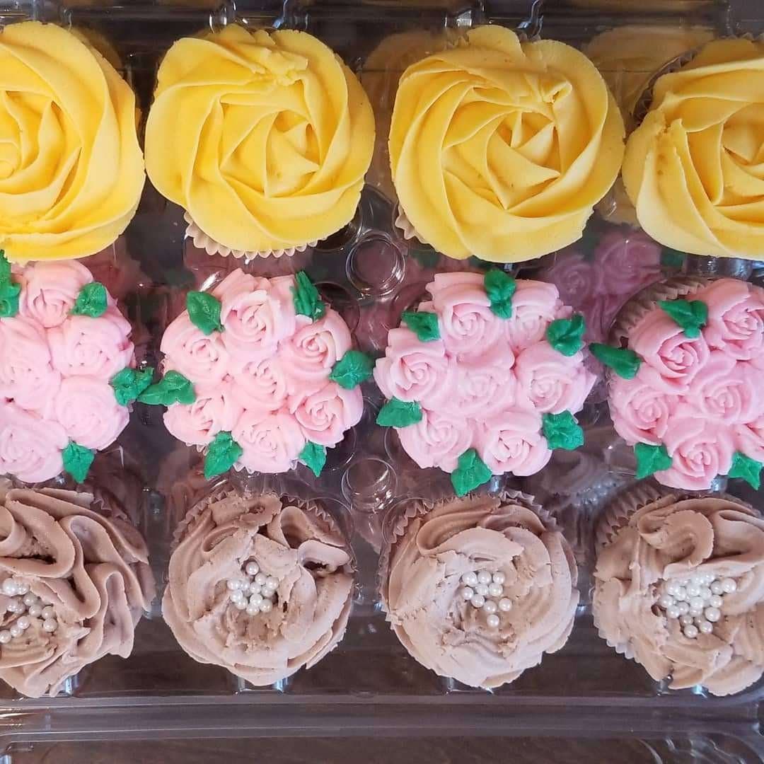 Floral buttercream cupcakes with yellow rosettes and pink blossoms by Jamie Cakes.