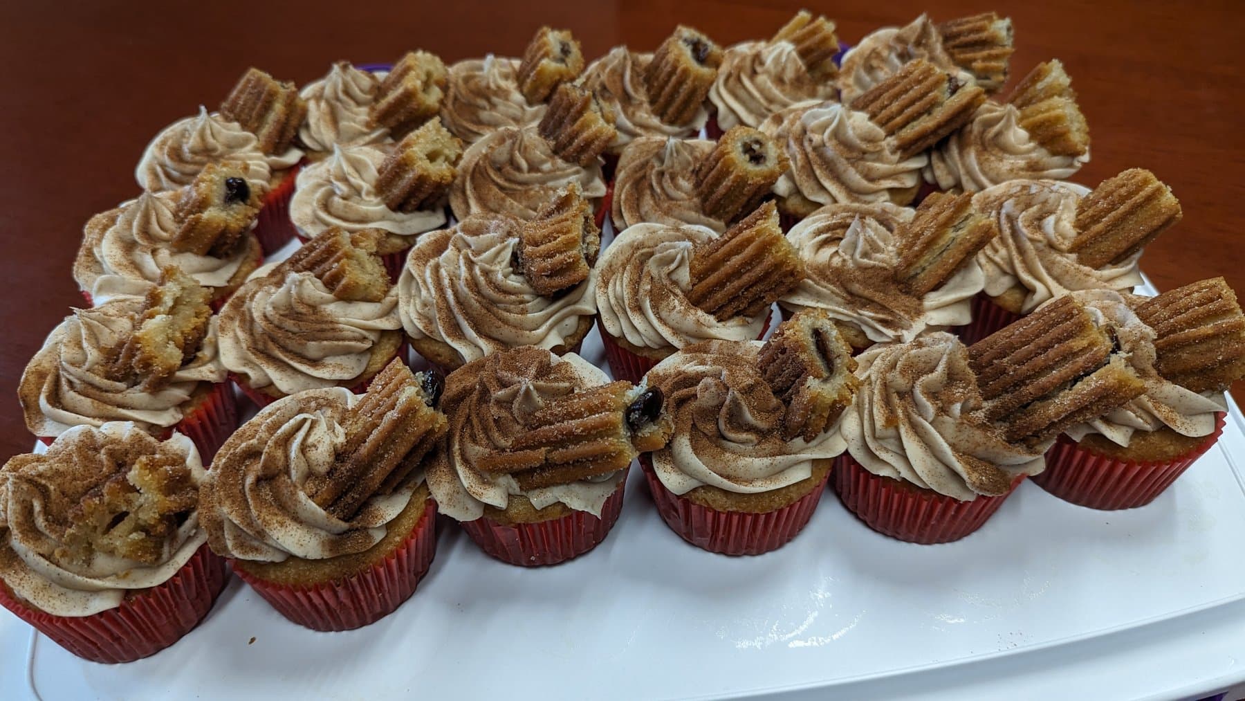 Churro cupcakes with cinnamon frosting and churro pieces by Jamie Cakes.