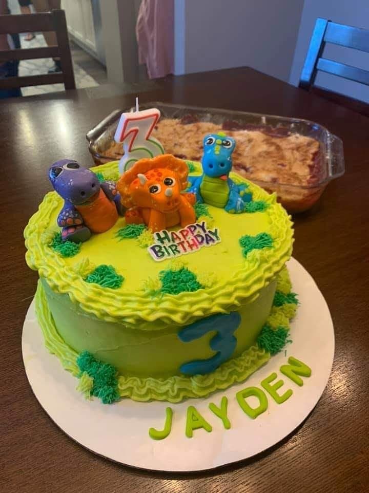 Colorful dinosaur birthday cake with bright toppers by Jamie Cakes.