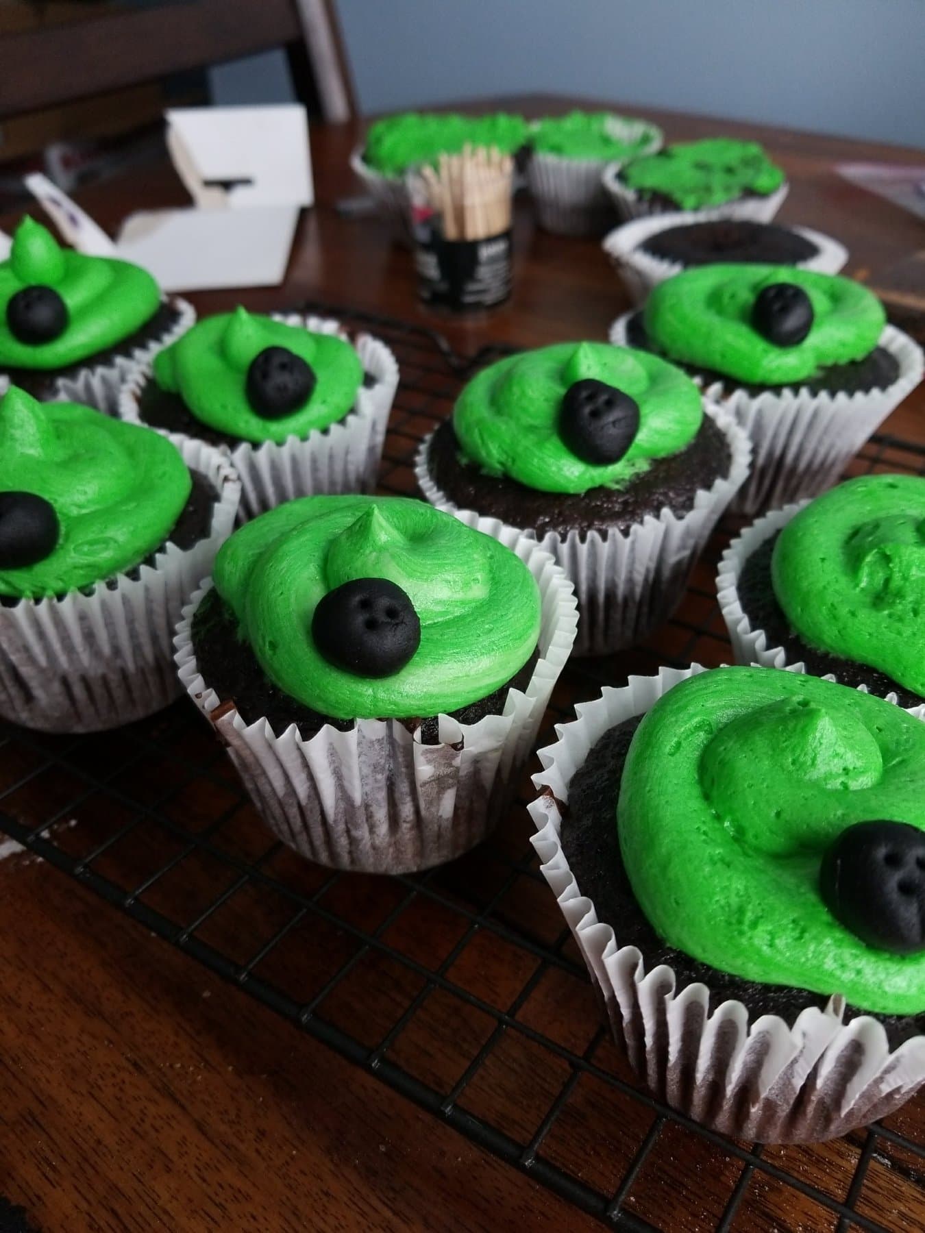 Monster-style green cupcakes with bold frosting swirls by Jamie Cakes.