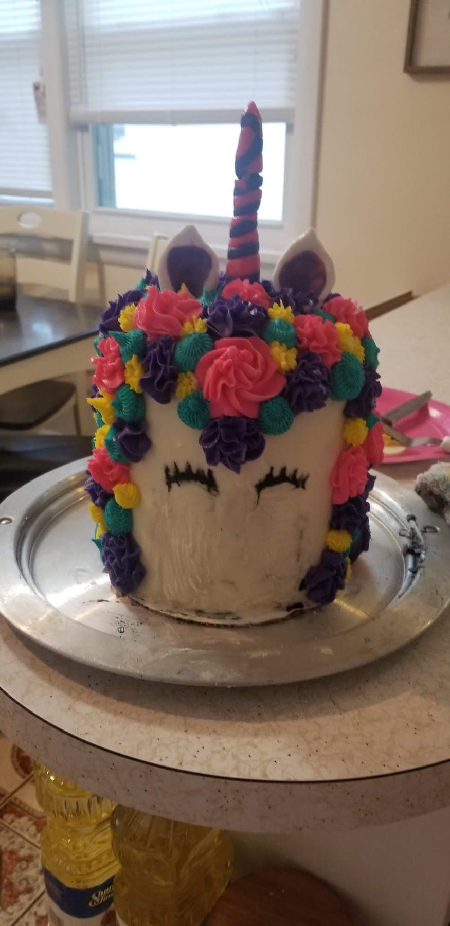 Unicorn birthday cake with floral buttercream mane and gold horn by Jamie Cakes.